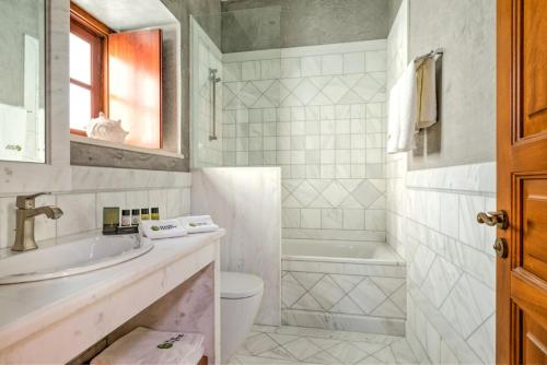 斯派赛斯Mare Monte Luxury Suites的浴室配有盥洗盆、卫生间和浴缸。