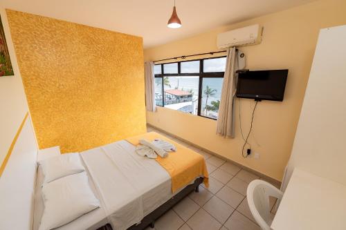 纳塔尔Pousada Terra do Sol Natal的酒店客房,配有床和电视