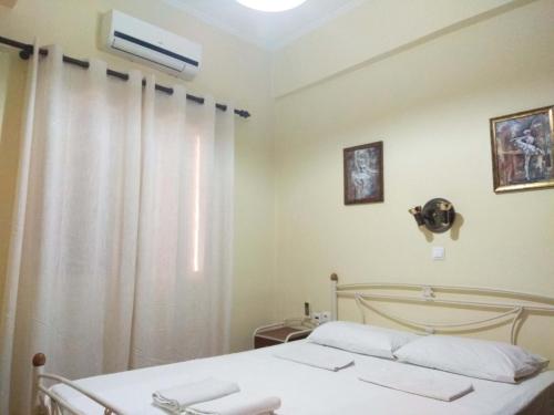 雷夫卡达镇OLEA Apartments的一间卧室配有一张床和一个带风扇的窗户。