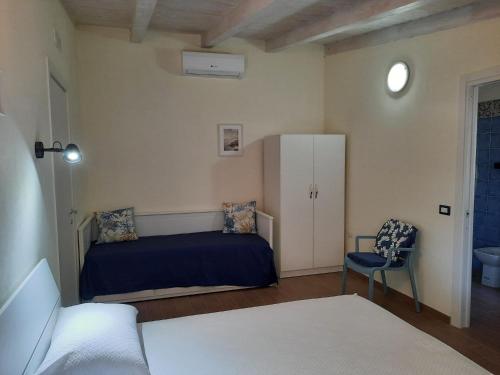 卡梅罗塔码头Villetta del Poggio的一间卧室配有一张床和一把椅子