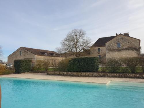 Conne-de-LabardeGite l'Herbier的一座大蓝色游泳池,位于房子前