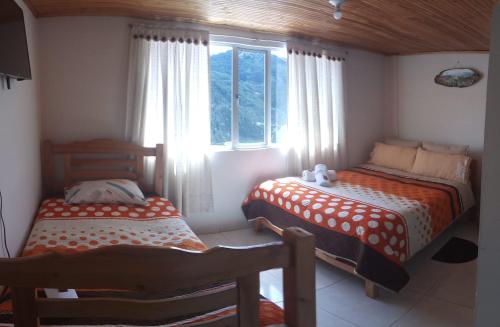 蒙圭Los Recuerdos de Florito y Leo的一间卧室设有两张床和窗户。
