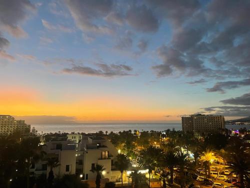 美洲海滩Las Americas Ocean View El Dorado的享有城市的日落美景,设有建筑和大海