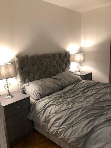 新港Exclusive Modern decorated 1 Bedroom Detached Studio的一间卧室配有一张床、两个床头柜和两盏灯。