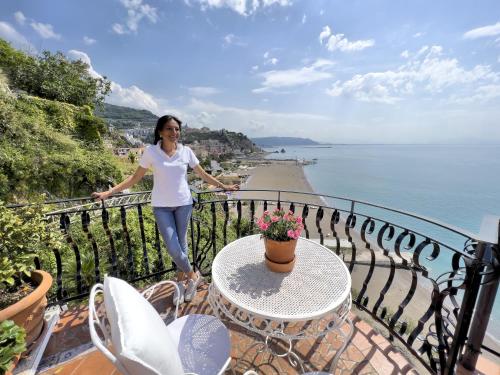 维耶特里Due Relais - Panoramic Sea View Suites的站在俯瞰水面的阳台的女人
