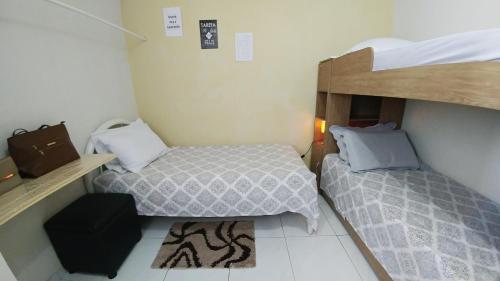若昂佩索阿Quarto Individual para 3 Pessoas em AP Compartilhado的一间小房间,房间内设有两张床