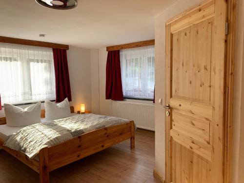SaupsdorfNaturhof Kluge的一间卧室配有一张床和一扇木门