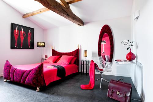 LegéLa Villa des Forges的一间卧室配有红色的床和镜子