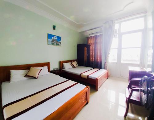 下龙湾Hoang Long Hotel Bai Chay的一间卧室设有两张床和窗户。