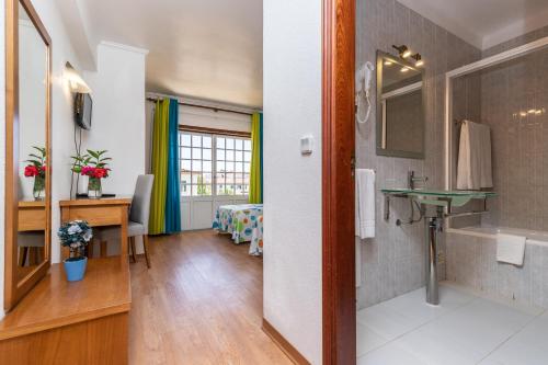 阿尔图拉Hotel Azul Praia的客房设有带水槽的浴室和书桌