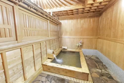 高野山高野山 宿坊 大明王院 -Koyasan Shukubo Daimyououin-的木墙客房的按摩浴缸