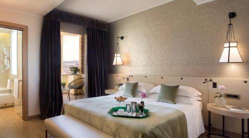 罗马星际都市酒店的一间卧室配有一张大床,上面有托盘