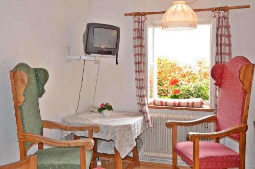 哈尔施塔特布劳伽斯特豪夫哈尔施塔特宾馆的客厅配有桌椅和电视。