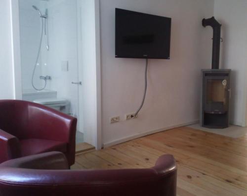 乌埃克尔明德老镇公寓的客厅配有椅子和墙上的电视