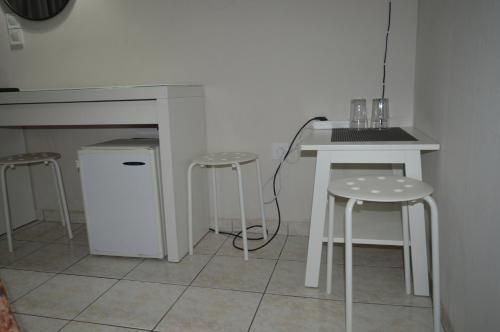 雅典阿尔比恩酒店的厨房配有2张凳子、1张桌子和1个柜台