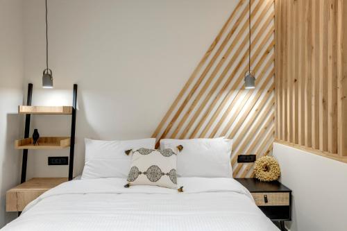 埃尔莫波利斯Argento urban apartment (sphere)的卧室配有白色的床和木制床头板