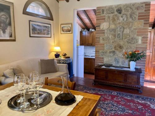蒙特里久尼Monteriggioni Castello的客厅配有带酒杯的桌子