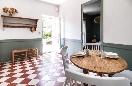 佩萨克Le clos Poujeau 15 mns centre Bordeaux的一间带木桌和椅子的用餐室