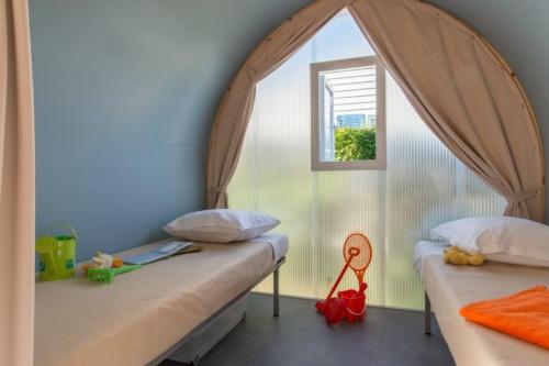 维亚斯Camping Club l'Air Marin的带窗户的客房内的两张床