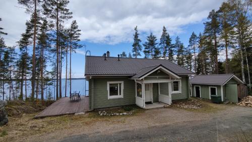 科林基拉Lake Cottage Jänisvaara的森林中间的一座小绿色房子