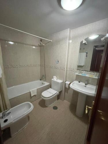 希洪法尔德斯酒店 的浴室配有盥洗盆、卫生间和浴缸。