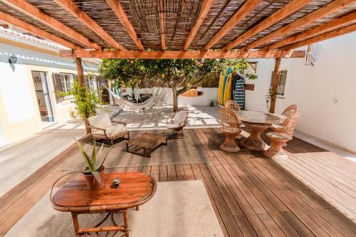 萨格里什LemonTree Eco Surfhouse的铺有木地板的庭院配有桌椅
