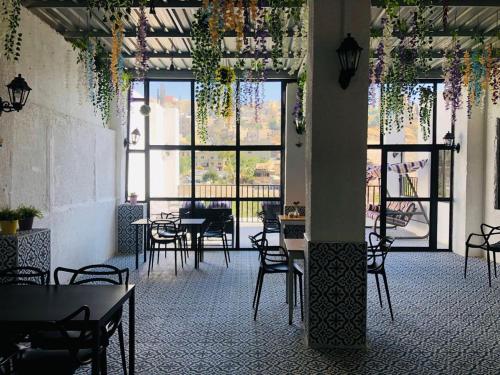 安曼扎曼雅扎曼精品酒店的一间设有桌椅的餐厅,位于带窗户的房间内
