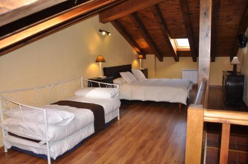 Horcajo de la SierraEl Rincón de la Trilla - El Linar的铺有木地板的客房内的两张床