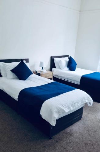 威克Caithness Inn的蓝色和白色的客房内的两张床