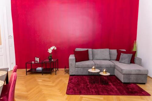 维也纳Schönbrunn Serenity Luxurious Ruby Apartment with Palace Views的带沙发和红色墙壁的客厅