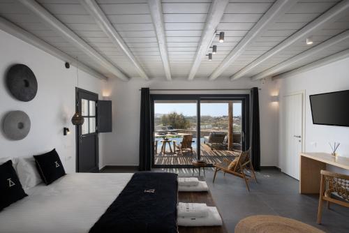 米克诺斯城Ikies of Mykonos的一间卧室配有一张床、一张书桌和一台电视