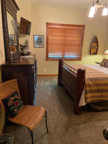 比格福克THE INN Bigfork Bay的卧室配有床、椅子和窗户。
