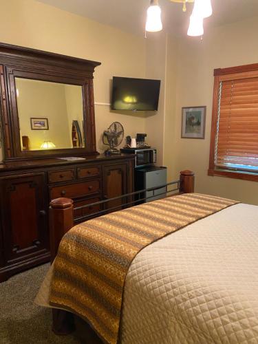 比格福克THE INN Bigfork Bay的一间卧室配有一张床、梳妆台和镜子