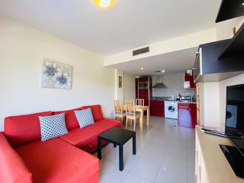罗列特海岸RELAX APARTAMENTO Playa Fenals的一间带红色沙发的客厅和一间厨房