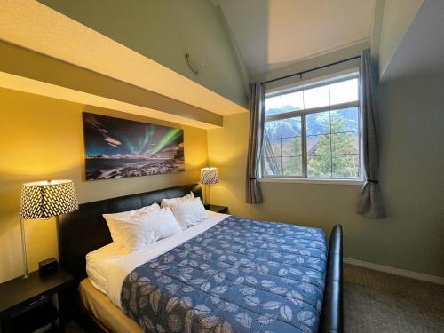 坎莫尔Renovated Chalet at Mystic Springs, Mountain Views, Pets Welcome!的一间卧室设有一张床和一个窗口