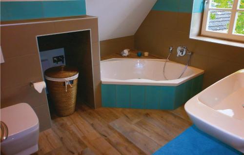 伯尔格伦德-雷特维施Haus Nixe的带浴缸、卫生间和盥洗盆的浴室