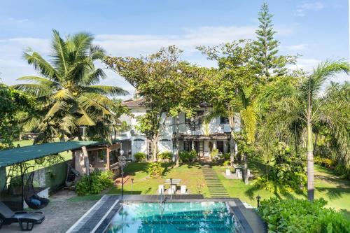 Pamunugama瑟拉库娃别墅的享有带游泳池和棕榈树的别墅的空中景致