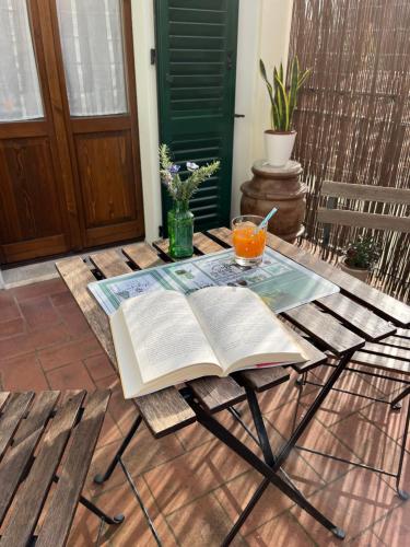 锡耶纳La Casina Verde的桌上的一本开放式书,上面放着一杯橙汁