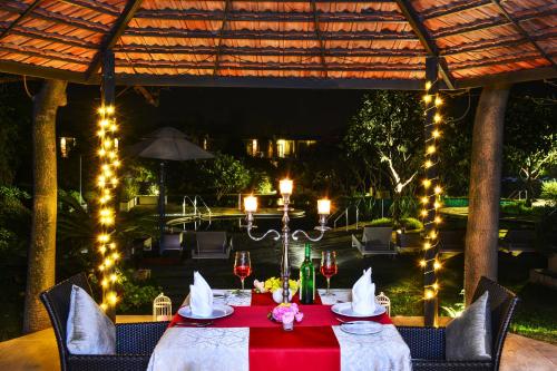 古尔冈The Gateway Resort Damdama Lake的一张带红桌布和灯的餐桌