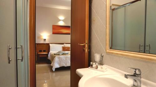 帕尔盖利亚Hotel Residence Piccolo的一间带水槽的浴室和一间带一张床的卧室