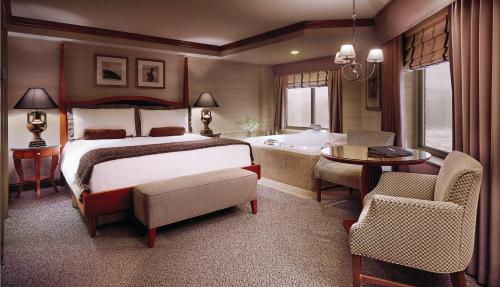 康瑟尔布拉夫斯康瑟尔布拉夫斯美洲星赌场酒店的一间卧室配有一张床,浴室设有浴缸