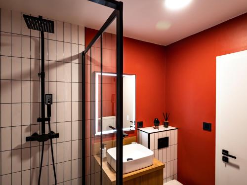 斯特拉斯堡Élégant studio à côté du Parlement的一间带红色墙壁、水槽和淋浴的浴室
