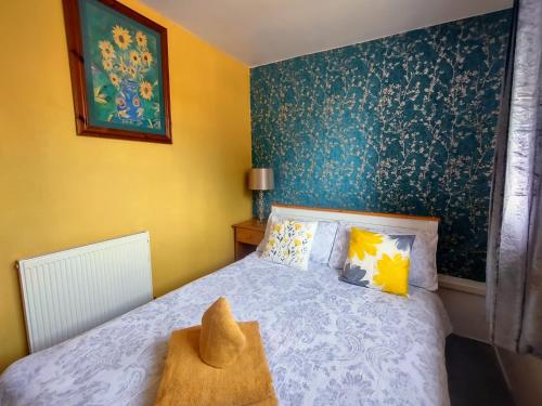 海茨托特The Shoulder at Hardstoft的一间卧室配有一张蓝色和黄色墙壁的床