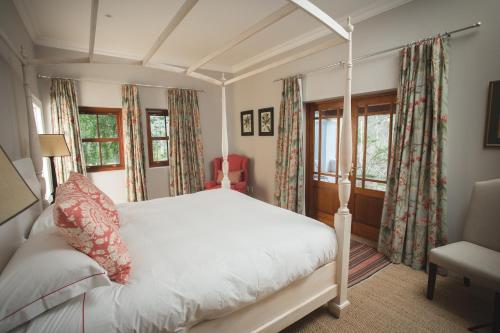 普利登堡湾Lombard Villa的卧室配有白色的床和2扇窗户。