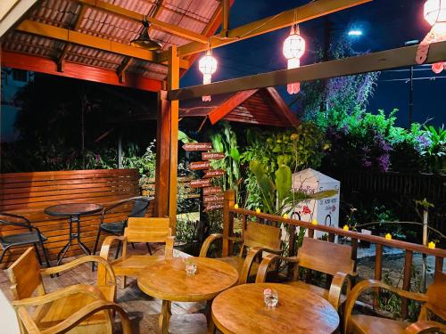 清迈DE ROSE Hotel Chiang Mai的餐厅设有木桌和椅子及灯