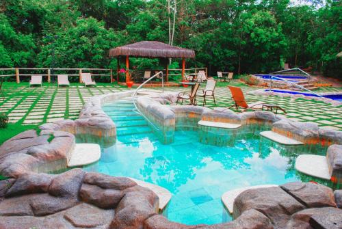 卡达斯诺瓦斯Ecologic Ville Resort - Oficial的一个带椅子的游泳池和一个凉亭