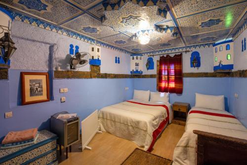 舍夫沙万拉西柏之家旅馆的蓝色墙壁客房的两张床