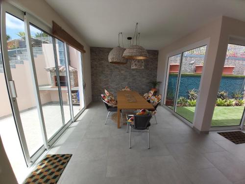 伊斯特雷托达卡耶塔Banda Do Sol Self Catering Cottages的客厅配有桌椅和窗户。