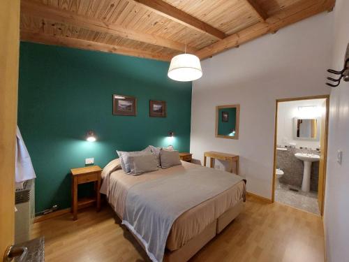 厄尔查尔坦Hospedaje Mi Rincón El Chaltén的一间卧室设有一张床和绿色的墙壁