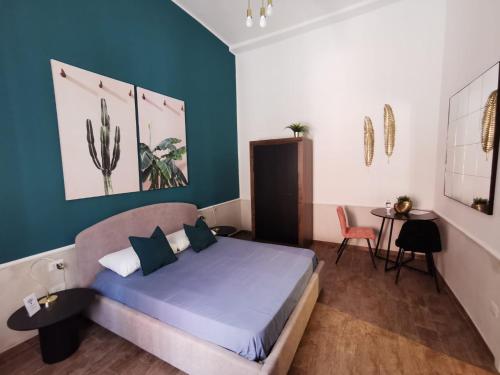 巴里Il Civico 2的一间卧室配有一张蓝色墙壁的床和一张桌子